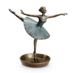 a bronze statue of a ballerina on a tray