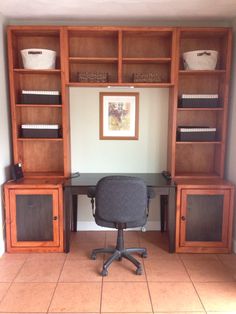 an office desk and bookcases in the corner of a room with tile flooring