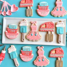 decorated cookies are arranged on a tray and ready to be cut into the shape of cooking utensils