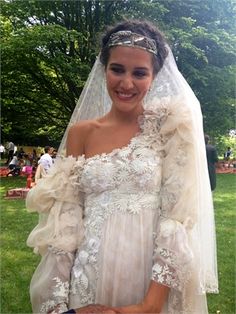 a woman in a wedding dress is smiling for the camera with her veil draped over her head