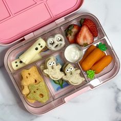 a bento box with food in it on a marble countertop next to strawberries, carrots and crackers