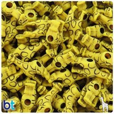 a pile of yellow dog bone beads with holes in the middle and eyes on them