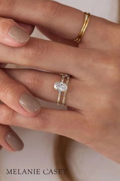 two women's hands with wedding rings on their fingers, one holding the other