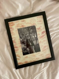 a black and white photo in a frame on a bed