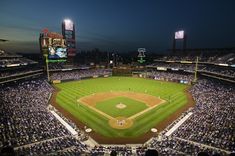 an aerial view of a baseball stadium at night with the lights on and fans in the stands