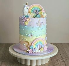 there is a cake decorated with unicorns and rainbows