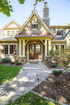 a house that is in the grass and has a stone walkway leading up to it