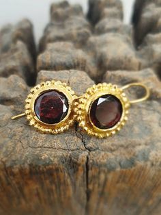 Gold earring with dark red garnet. Designer vintage style earrings. Minimalist design.  Delicate earrring.These are 14 karat gold plated brass designer delicate handmade earrings, which have a simple romantic design. The earrings are set with a  dark red garnet gem. Garnet drop earrings in an antique look. January birthstone earrings.The round faceted garnet (in dark wine red ) is framed with gold dots all around.The  earrings are beautiful  glamorous, and light, and you will not want to take  t Elegant Handmade Garnet Earrings, Handmade Elegant Garnet Earrings, Garnet Birthstone Drop Earrings, Handmade Garnet Earrings For Anniversary, Delicate Bridal Earrings, Vintage Earrings Gold, Garnet Drop Earrings, Red Garnet Earrings, Big Statement Earrings