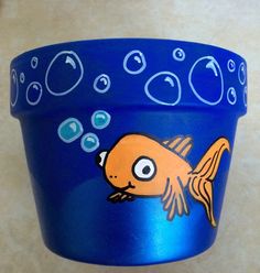 a blue cup with an image of a fish on the bottom and bubbles around it