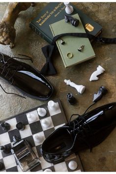 a pair of black shoes sitting on top of a checkered floor next to a chess board