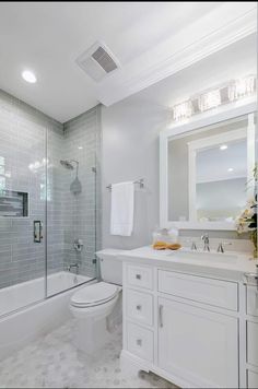 a white bathroom with glass shower doors