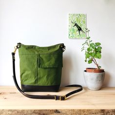 Crossbody bag - INCH - Green waxed canvas  - waterproof zipped shoulder purse - adjustable leather crossbody strap made by HOLM This bag provides just the right amount of space for your daily travel essentials - wallet, keys, water bottle, book etc.   Constructed with the best quality Scottish made waxed canvas specifically maufactured to be waterproof and withstand the rigours of any weather.  Brown leather base accompanies the look giving this crossbody the usual understated HOLM style. Full width best quality YKK zipper keeps your valuables stylishly safe .  The exterior has a handy slip pocket and the interior is lined in French striped ticking fabric with one zipped pocket to keep smaller items even more secure.  Fully adjustable shoulder / crossbody leather strap so that you can fit Outdoor Shoulder Bag With Adjustable Strap In Coated Canvas, Outdoor Shoulder Bag With Adjustable Strap And Coated Canvas, Green Shoulder Bag With Canvas Lining For Outdoor, Functional Waxed Canvas Crossbody Shoulder Bag, Outdoor Waxed Finish Crossbody Shoulder Bag, Green Leather Shoulder Bag With Canvas Lining, Functional Crossbody Shoulder Bag With Waxed Finish, Outdoor Crossbody Shoulder Bag With Leather Handles, Functional Waxed Finish Crossbody Shoulder Bag