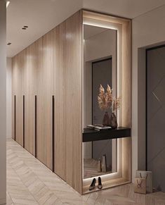 an empty hallway with wooden walls and flooring is lit up by the bright lights on the mirror