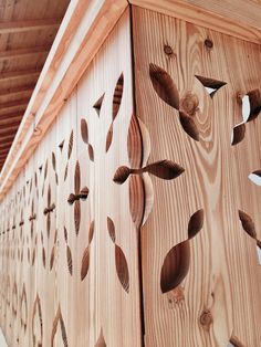 wood carvings on the side of a wooden structure with leaves carved into it's sides