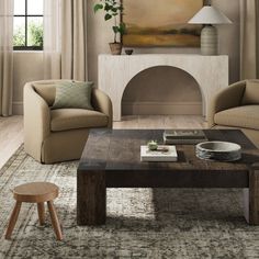 a living room with two couches and a coffee table in front of a fireplace