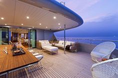 a large wooden table sitting on top of a deck next to a living room and dining area