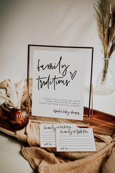 a table with some writing on it next to a vase filled with flowers and feathers