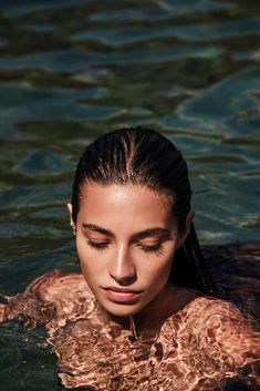 a woman in the water with her eyes closed