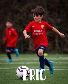 two young boys are playing soccer on the field