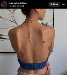 the back of a woman's body with tattoos on her upper and lower back