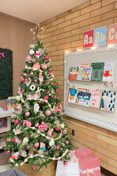 a decorated christmas tree in front of a brick wall with pictures on the wall behind it