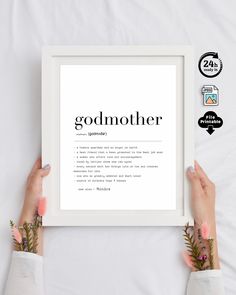 two hands holding up a white framed print with the words godmoter above it