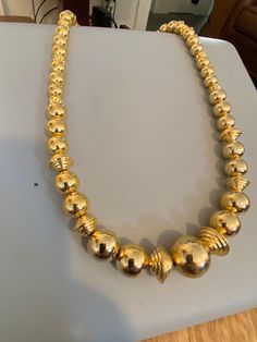 "From the estate of a woman who had a massive costume jewelry (mostly Avon) collection. This piece is a graduated gold bead necklace strung on a chain. Some of larger round beads toward the center of strand are flanked by large ribbed gold saucer beads. This necklace uses a spring ring closure. This piece is in excellent vintage condition. Signed: Korea Measurements Length: 28\" Largest Bead: .75\"" Formal Gold Necklaces With Spacer Beads, Classic Gold Beaded Necklaces, Classic Gold Beaded Necklace, Formal Costume Jewelry Necklace With Large Beads, Gold Necklaces With Large Round Beads, Formal Large Beads Costume Jewelry Necklace, Gold Beaded Necklace For Formal Events, Gold Large Beads Costume Jewelry Necklace, Gold Beaded Necklaces With Spacer Beads For Formal Occasions