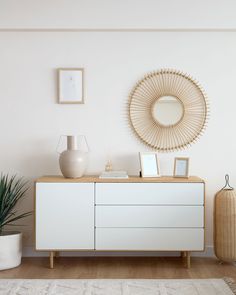 a white dresser sitting next to a mirror on top of a wall