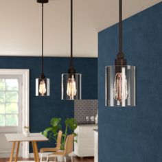 a kitchen and dining room with blue walls, wood flooring and pendant lights hanging from the ceiling