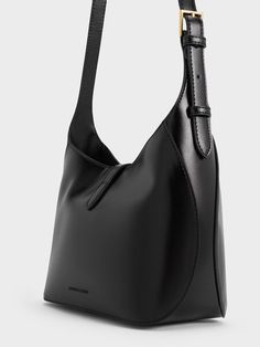 This product is made with at least 20% sustainable materials by weight. CHARLES & KEITH uses recycled, degradable, organic, and water-based materials in our eco-conscious collection. You will always look polished and put together with the Wisteria shoulder bag in tow. It features an elegant black finish that will go with everything in your wardrobe and a gold-toned accent that adds understated glamour to the design while keeping your belongings secure. The shoulder strap is also adjustable so you can carry it at your preferred drop length. Large Black Handbag, Vintage Prada Bag, Charles And Keith Bags, Understated Glamour, Look Polished, Accessories Bags Shoes, Chic Bags, Charles Keith, Black Leather Handbags