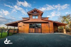 a large wooden building sitting on top of a lush green field