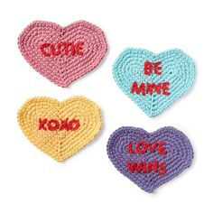 three crocheted hearts with words on them