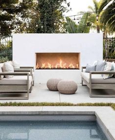 an outdoor fireplace with two couches and a fire place in the middle of it