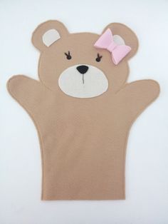 a brown teddy bear with a pink bow on it's head and hands in the shape of a hand