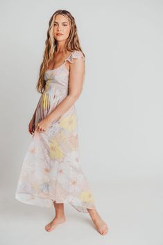 Look effortlessly pretty in our romantic Tuva Flutter Sleeve Maxi. With its pastel hues and enchanting floral pattern, this dress will have you feeling like a fairy-tale princess. Its open back detail and flutter cap sleeves make it both sophisticated and charming; pair it with a straw clutch and heeled sandals for your next special occasion. FIT: Runs true to size. Size up for maternity. MODEL: Mackenzie is 5’7” / 130lb / wearing a small. MATERIAL: 100% Polyester. GARMENT DETAILS: Pastel floral Flowy Floral Print Midi Dress With Ruffled Straps, Flowy Floral Midi Dress With Ruffled Straps, Feminine Cap Sleeve Summer Dress, Feminine Floral Print Dress With Ruffle Sleeves, Feminine Floral Dress With Flutter Sleeves For Brunch, Feminine Floral Dress With Ruffle Sleeves For Spring, Feminine Ruffled Cap Sleeve Dresses, Feminine Cap Sleeve Dresses For Spring, Feminine Cap Sleeve Dresses With Ruffles