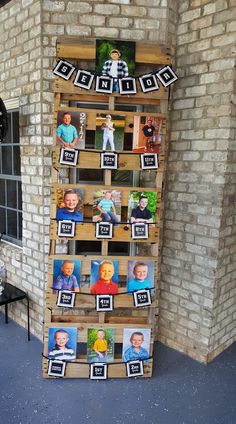 a display made out of pallets with pictures on them and photos hanging from the top