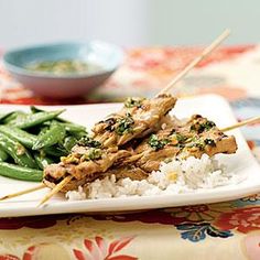 a plate with rice, meat and green beans on it