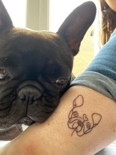 a dog with a tattoo on it's arm is being held by a woman