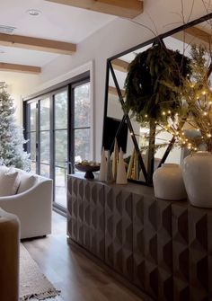 a living room filled with white furniture and christmas decorations on top of a wooden floor