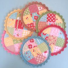 four patchwork coasters are arranged on a blue surface