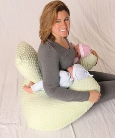 a woman sitting on a bean bag chair holding a baby in her arms and smiling at the camera