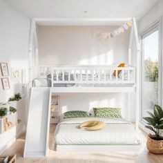 a white bunk bed sitting in a bedroom next to a plant and potted plants