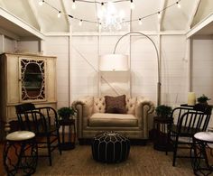 a living room filled with furniture and a chandelier hanging over the top of it