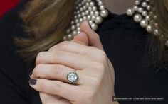 a close up of a person wearing a ring with pearls on the neck and hands