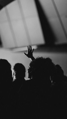 a black and white photo of people raising their hands