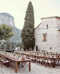 an outdoor dining area with tables and chairs set up in front of a stone building