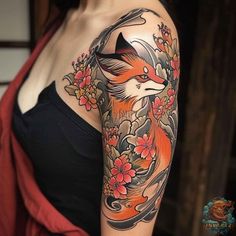 a woman's arm with an orange and black fox tattoo on her left shoulder