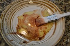 a paintbrush sitting on top of a white plate filled with burnt food and brown stuff