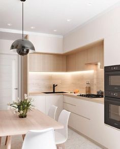 a kitchen with two ovens sitting next to each other on top of a wooden table