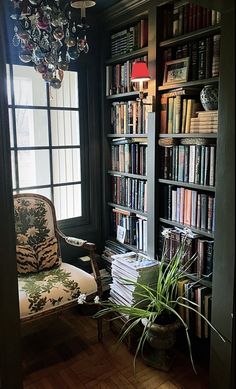 a chair in front of a bookshelf filled with lots of books next to a window